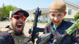 Nightmare PB posing with his son, holding an EMF200 magfed paintball marker, both smiling in paintball gear.
